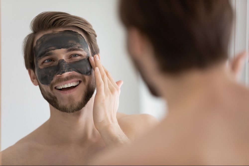 man applying skincare face mask