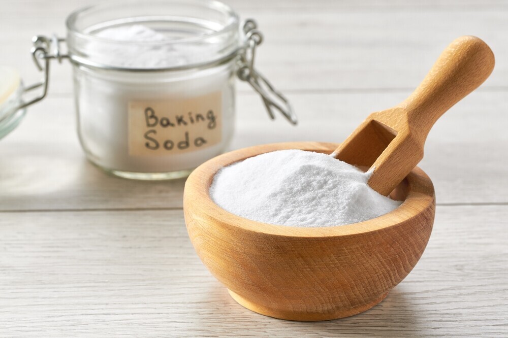 baking soda in wooden bowl with wooden spoon